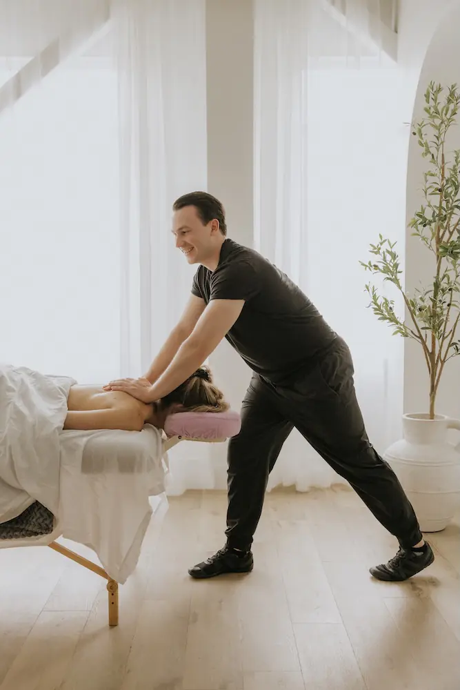 Devin Brown, Registered Massage Therapist at Triada Health Ottawa, providing sports massage treatment for athletes and recovery.