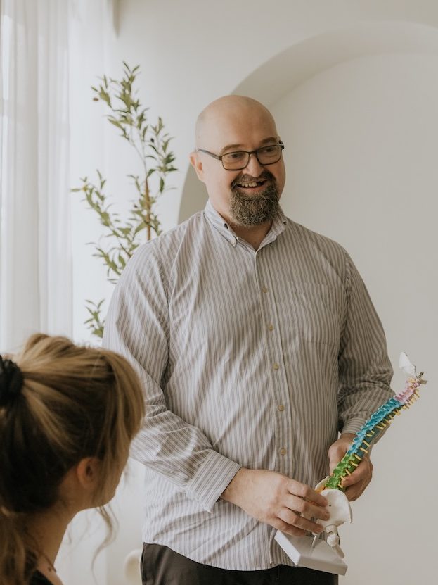 Dr. Andrew Bell, chiropractor at Triada Health Ottawa providing chiropractic education to a patient about spine health